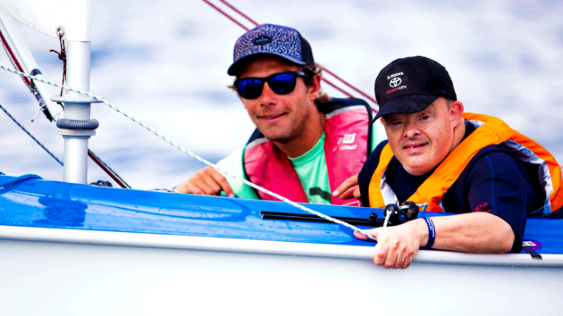 Sailors smiling at the camera in a boat